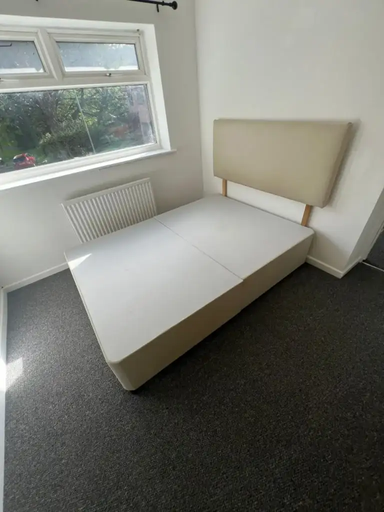 Divan bed base and headboard ready to be removed from a bedroom