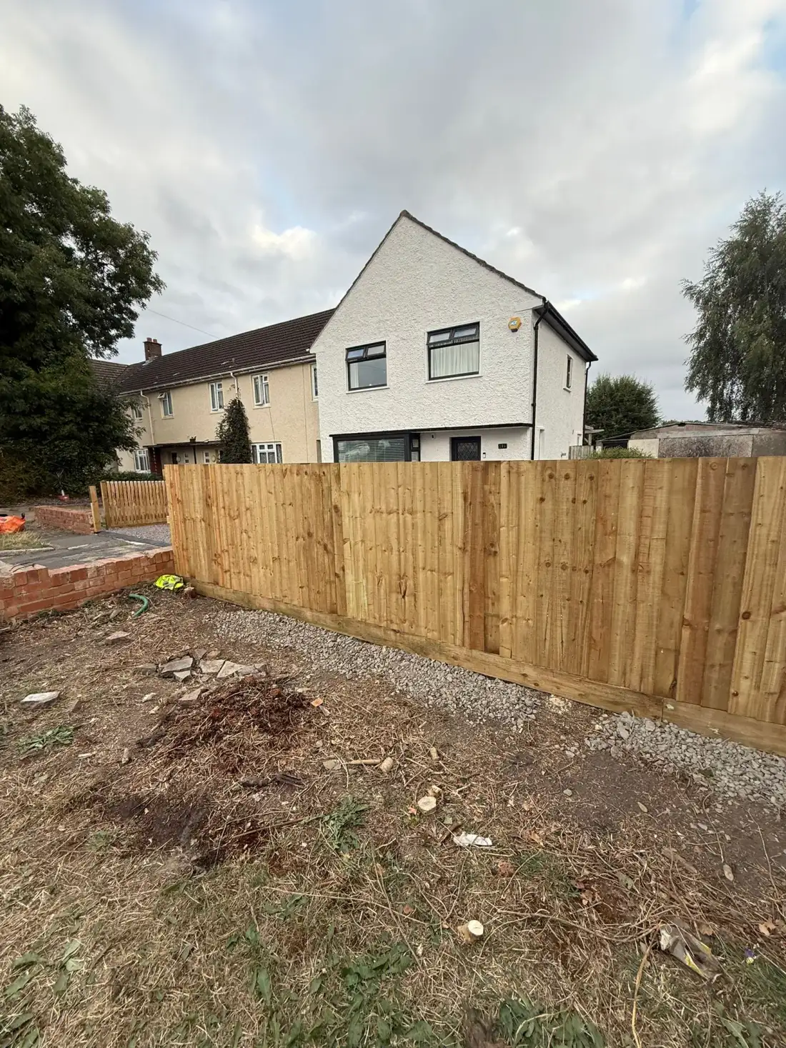 New feather-edge timber fence along the side of a garden