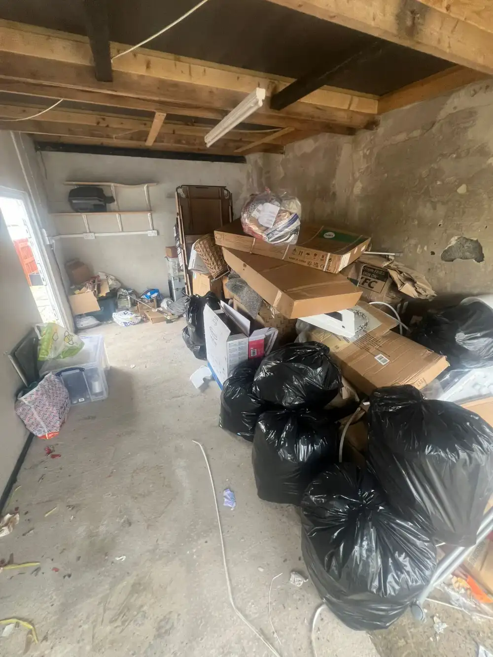 Garage stacked with boxes and black bags before a clearance