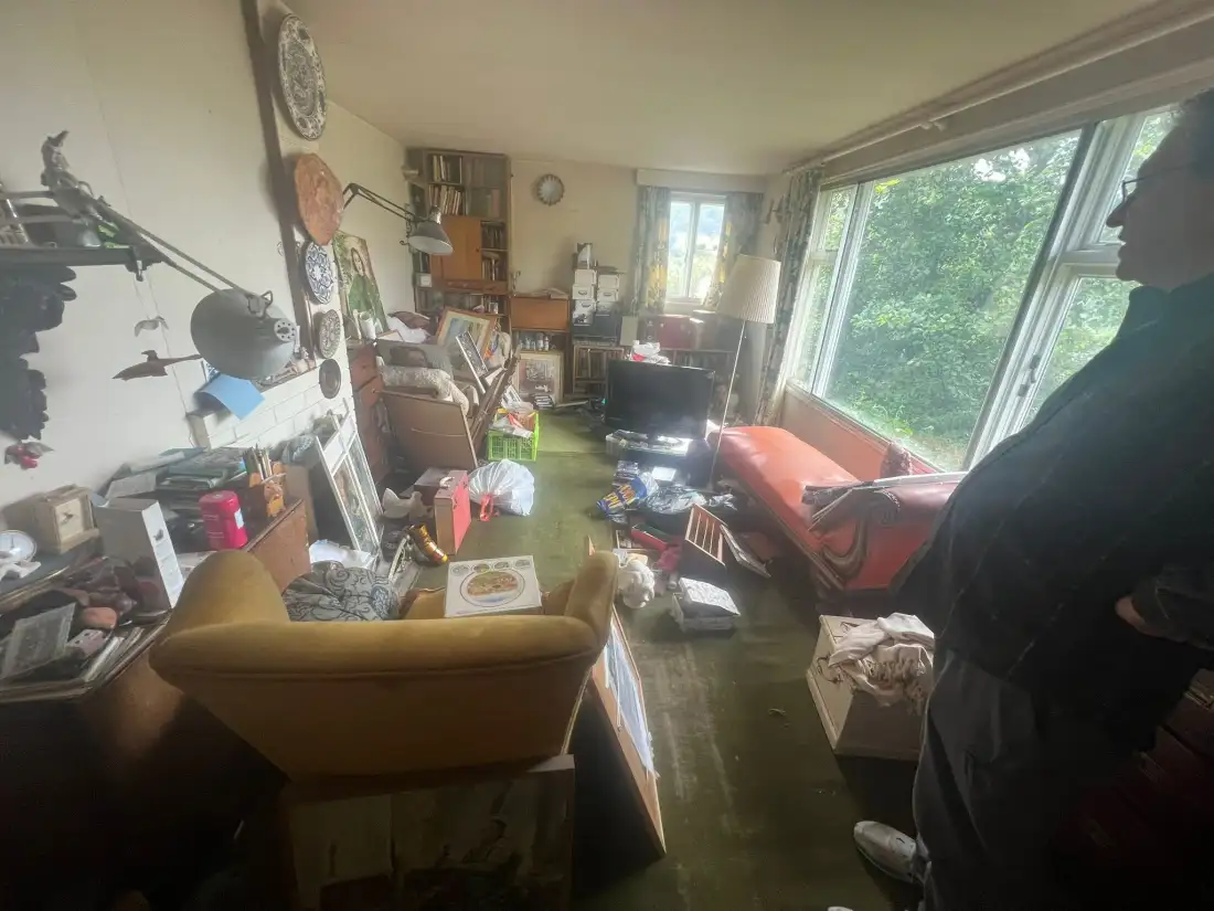 Living room full of furniture and belongings before a full property clearance