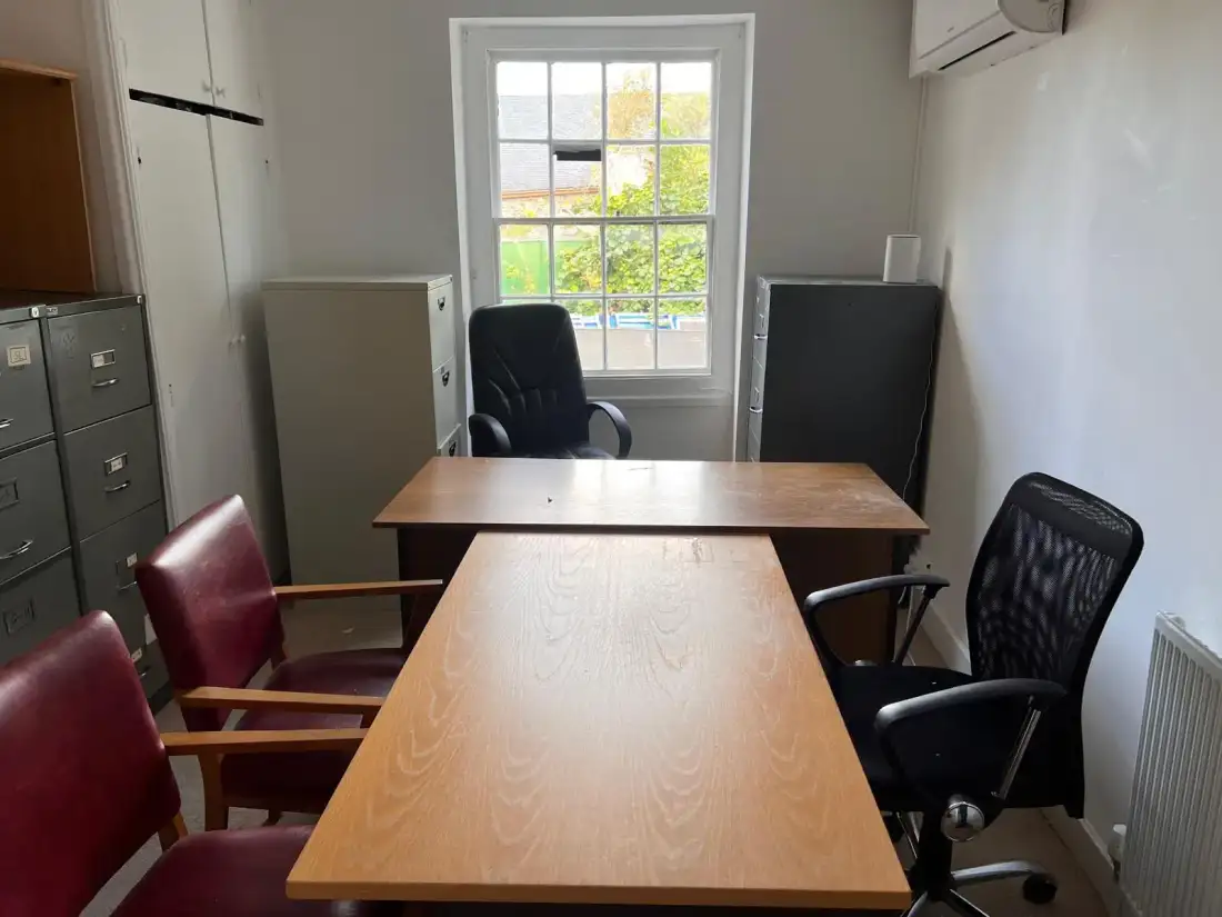 Meeting table, chairs and filing cabinets in an office being cleared