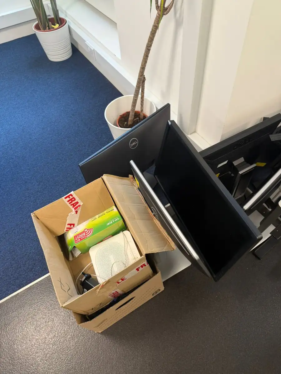 Boxed-up office equipment and a monitor waiting to be collected