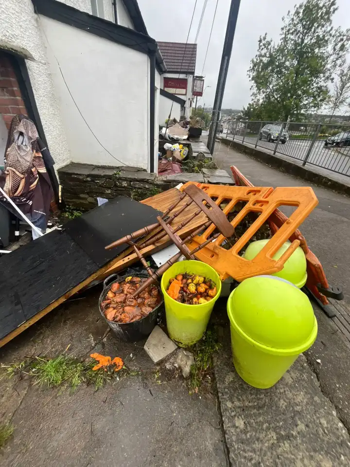Old furniture and waste gathered outside a pub during a clearance