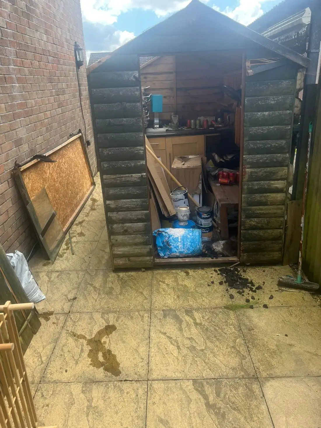 Small timber shed with its doors open on a patio