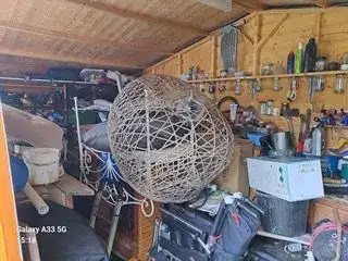Shed interior packed with tools, storage boxes and garden items