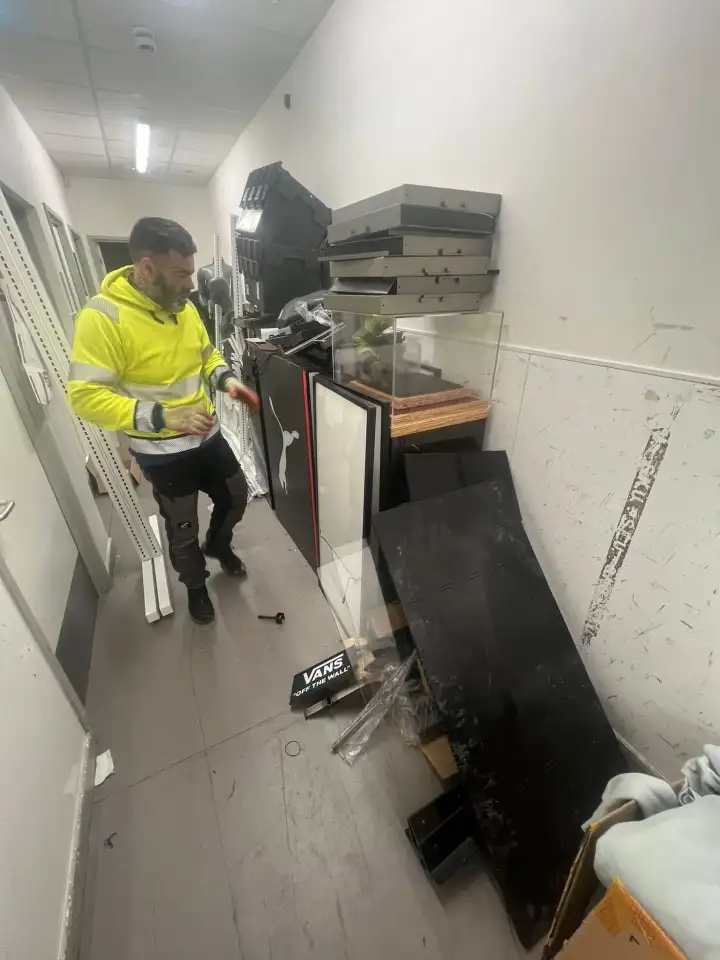 TJB team member clearing fixtures from the back corridor of a shop