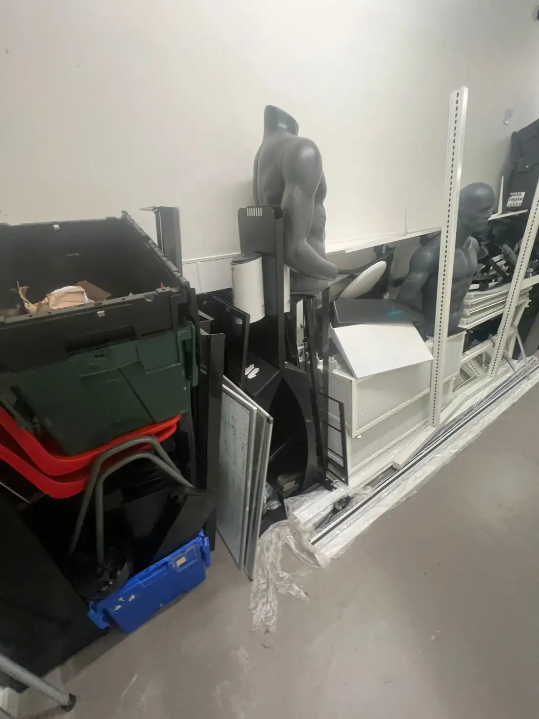 Shop display fixtures and crates stacked in a corridor for removal